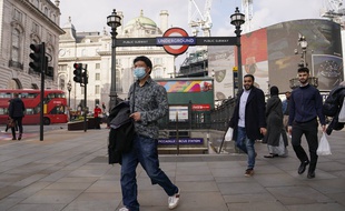 Un homme portant un masque devant la station de métro Piccadilly Circus, à Londres le 19 octobre 2021.