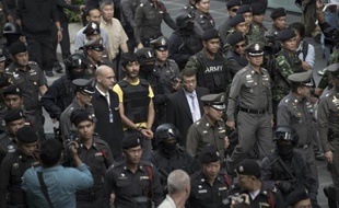 Un suspect (centre) dans l'attentat à la bombe de Bangkok est escorté par la police lors de la reconstitution des faits dans le centre de la capitale thaïlandaise, le 9 septembre 2015