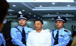 Des personnes regardent sur un écran l'ex-dirigeant chinois Bo Xilai, condamné à la prison à vie après son procès à Jinan, le 22 septembre 2013