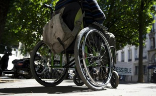 Une personne en fauteuil roulant participe à une manifestation pour demander plus d'accessibilité, devant l'Assemblée nationale, le 06 juillet 2015 à Paris