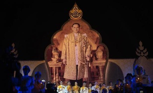 Portrait géant du roi Bhumibol Adulyadej devant le Grand Palais à Bangkok lors du 87 anniversaire du monarque, le 5 décembre 2014. Parmi les hauts dignitaires soutenant des bougies au premier plan, le premier ministre Chan-O-Cha (à g)