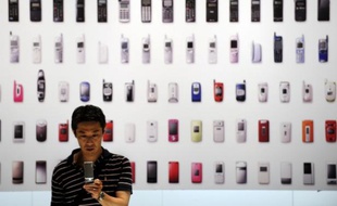 Un homme se servant de son téléphone portable lors d'une exposition sur les mobiles, à Tokyo, le 23 mai 2010