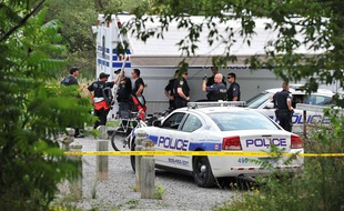 Des enquêteurs près de l'endroit où a été retrouvé la tête d'une femme, le 16 août 2012, à Mississauga (Canada).
