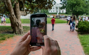 Une femme se promène dans la rue en jouant au Pokemon Go sur son téléphone, le 21 juillet 2016 à Washington