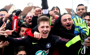 Le portier de l'Olympique Strasbourg entouré d'autres joueurs et du public du club du quartier de Cronenbourg en périphérie de la capitale alsacienne.