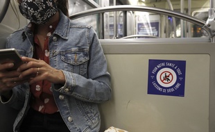 Une passagère du métro utilise son smartphone à Paris le 9 mai 2020 (photo d'illustration)