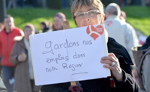 Illustration d'une femme brandissant une pancarte lors d'une manifestation en faveur du maintien du Crédit Mutuel Arkea en 2016 à Brest.