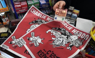 Une femme achète à Montpellier un exemplaire du Charlie Hebdo sorti le 25 février 2014