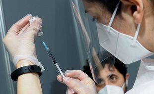 Illustration d'un soignant prêt à recevoir une injection du vaccin AstraZeneca.
