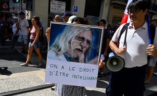 Une manifestante brandit une pancarte de soutien à Didier Raoult, le 21 août dernier, à la manifestation anti-pass sanitaire de Marseille. (Illustration)