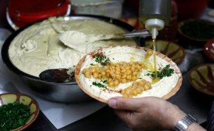 Un restaurateur palestinien prépare un plat de hoummous, purée froide à base de pois chiches, dans la vieille ville de Jérusalem, le 12 septembre 2015