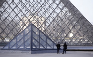 Des policiers patrouillent devant la pyramide du Louvre après l'attaque de militaires.