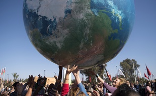 Des membres des délégations internationales jouent avec un globe géant, lors de la conférence de la COP22, le 18 novembre 2017 à Marrakech, au Maroc.