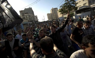 Des Palestiniens pleurent la mort de Mohammad Fassih tué lors d'un raid aérien israélien sur sa voiture à Gaza le 27 juin 2014