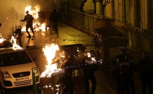 Des policiers touchés par des cocktails molotov tentent d'éteindre les flammes, lors d'affrontements avec des manifestants à Corte, en Corse, le 16 février 2016