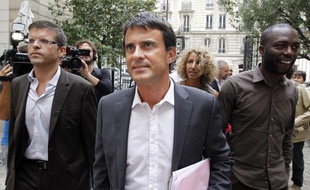 Manuel Valls, avec son directeur de campagne, Luc Carvounas (à gauche) et son porte-parole, Ali Soumaré (à droite), arrivent au siège du PS à Paris, le 22 août 2011.