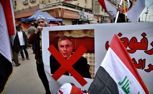 Des manifestants portent une pancarte contre le Premier ministre irakien désigné Mohammed Allawi, à Bagdad le 1er mars 2020.