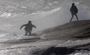 Un homme et sa fille sur les rochers balayés par les vents de la tempête tropicale Irene, à Peggy's Cove, en Nouvelle-Ecosse, au Canada, le dimanche 28 août 2011.
