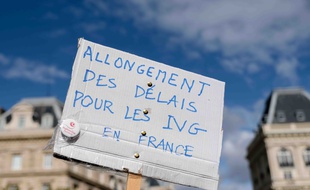 Une manifestante tient une pancarte réclamant l'