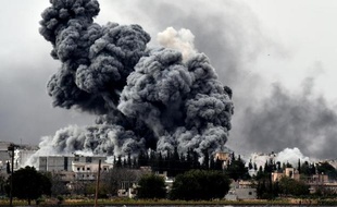 Une épaisse fumée noire s'élève de la ville de Kobané où les forces kurdes résistent farouchement aux jihadistes de l'EI, le 12 octobre 2014 à Mursitpinar, à la frontière syro-turque