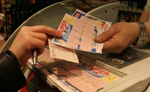 Un client achète une grille de Super Loto chez un buralistes parisien le vendredi 13 août 2010.