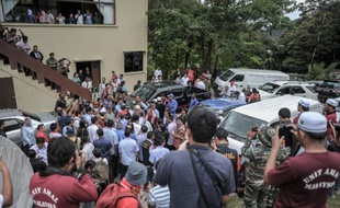 Soldats, journalistes et membres du gouvernement sont évacués lors d'une conférence de presse perturbée par une réplique du séisme près du Mont Kinabalu en Malaisie, le 7 juin 2015