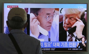 Un homme regarde un écran montrant le président américain Donald Trump en discussion téléphonique avec le président sud-coréen Moon Jae-in à la gare de Séoul en Corée du Sud le 5 septembre 2017.