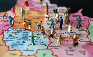 Des figurines sur une carte de France illustrant la réforme territoriale