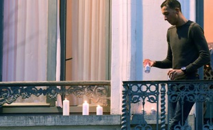 Mohamed Abdeslam, le frère d'un des kamikazes qui s'est fait sauter à Paris, dispose discrètement des bougies au balcon de la maison familiale, le 18 novembre 2015 à Molenbeeck