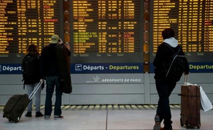 Des passagers devant le tableau des départs le 26 janvier 2016 à l'aéroport Charles-de-Gaulle à Roissy