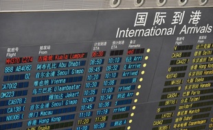 Le panneau d'affichage des arrivées de l'aéroport de Pékin montre le vol de Kuala Lumpur comme