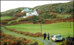 Des policiers irlandais surveillent la route montant à la villa de Sophie Toscan du Plantier, le 24 décembre près du village de Schull dans le sud de l'Irlande