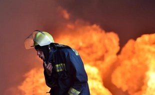 Un pompier ukrainien près du gigantesque brasier qui fait rage dans un dépôt pétrolier près de Kiev, le 9 juin 2015