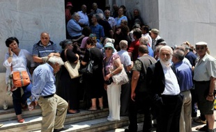 Des retraités font la queue le 29 juin 2015 dans le centre d'Athènes, à l'extérieur d'une agence de la Banque nationale de Grèce pour savoir quand et comment ils pourront toucher leur pension