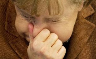 La chancelière allemande, Angela Merkel, étouffe un éternuement au Bundestag, à Berlin, le 24 mars 2011.
