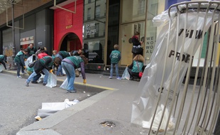Les membres du collectif Greenbird nettoient bénévolement les abords des Galeries Lafayettes, dimanche 21 février 2016, à Paris.