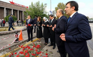Photo fournie le 13 octobre 2015 par le service de presse du ministère turc des Affaires étrangères montrant le Premier ministre Ahmet Davutoglu et d'autres membres du gouvernement priant sur le site de l'attentat d'Ankara