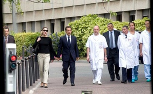 Nicolas Sarkozy quitte l'hôpital du Val-de-Grâce où il a passé la nuit après un malaise, escorté par des membres de l'équipe médicale,le 27 juillet 2009.