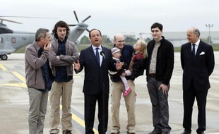 Le président François Hollande entouré des quatre ex-otages et de Laurent Fabius (droite) à l'aéroport de Villacoublay le 20 avril 2014