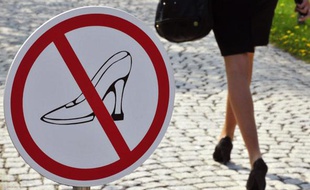 Une femme en talons hauts passe devant un panneau signalétique les interdisant à Ingelheim, Allemagne, le 20 avril 2010.