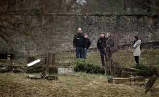 Des enquêteurs examinent le 16 février 2015 les tombes profanées du cimetière juif de Sarre-Union, dans le Bas-Rhin