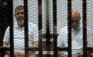 L'ancien président egyptien et son ex chef d'état major Rafaa el-Tahtawi assistent, derrière une cage, à leur procès le 14 octobre 2014 au Caire