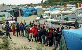 Des migrants font la queue pour recevoir de la nourriture dans la "Jungle" de Calais le 18 mai 2016