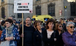 Un homme brandit une pancarte "Pour la paix et contre le terrorisme" durant une minute de silence en hommage aux victimes de l'attaque de Paris, le 14 novembre 2015 à Barcelone