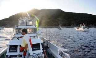 Ils ont les yeux rougis de sommeil, mais ils sont heureux. Lorsqu'en contrejour est apparu dimanche dans le soleil levant l'imposante masse rocailleuse et boisée de l'île Uotsurijima, les 150 militants nationalistes japonais sont comme électrisés. Les îles Senkaku, que revendique la Chine à cor et à cri, sont là, devant eux.