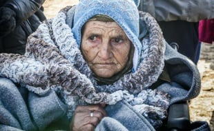Une femme âgée arrive en chaise roulante dans le village serbe de Miratovac en provenance de Macédoine, le 28 janvier 2016