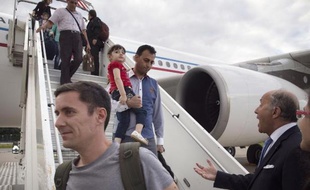 Des réfugiés irakiens chrétiens à leur arrivée à Paris le 21 aout 2014, accueillis par le ministre des Affaires étrangères Laurent Fabius