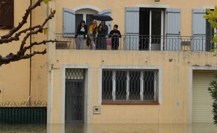 Des gens sur un balcon après les inondations dans le village du Muy, le 24 novembre 2019 Valery HACHE / AFP