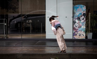 Une japonaise affronte les vents violents après le passage d'un typhon en 2018.