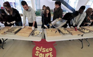 Des volontaires épluches des fruits et légumes invendus, lors d'une action de sensibilisation sur le gaspillage alimentaire, le 15 octobre 2014 à Reims